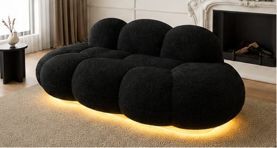 A black bouclé cloud sofa with warm LED underglow
