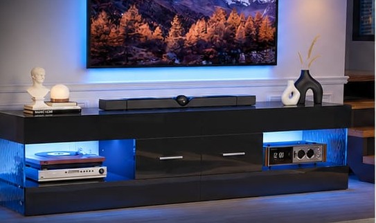 A high-gloss LED media unit in a living room, lit from within